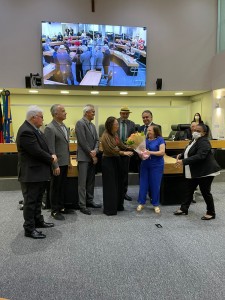 A mãe da homenageada, Sra. Ivonete, entrega o ramalhete de rosas a Dra. Rivana Ricarti